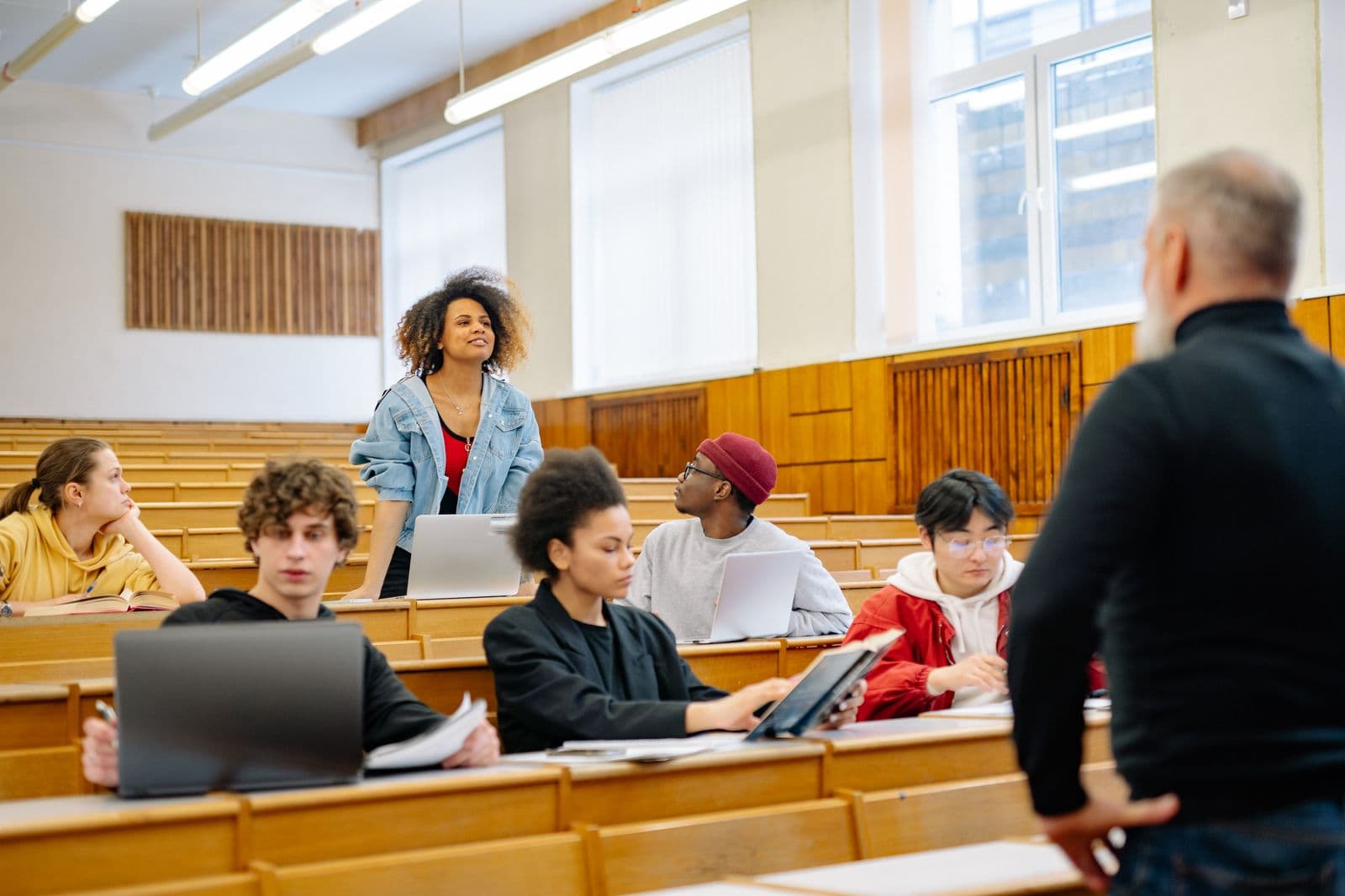 A student standing to answer a question in a lecture hall